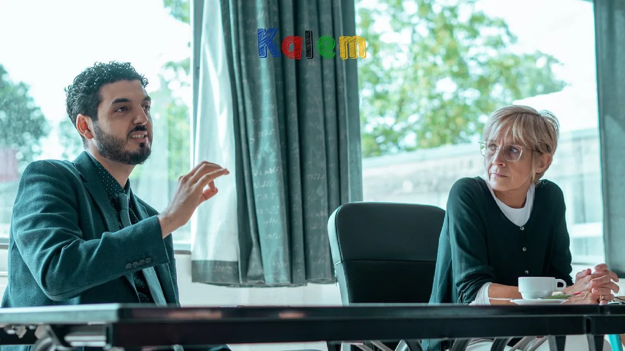 Twee volwassenen zitten aan een tafel in gesprek.